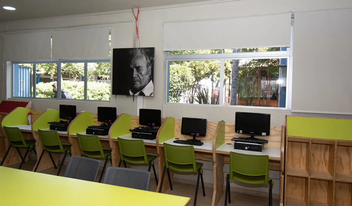 Sala de informática con puestos junto a ventanas con cortinas roller