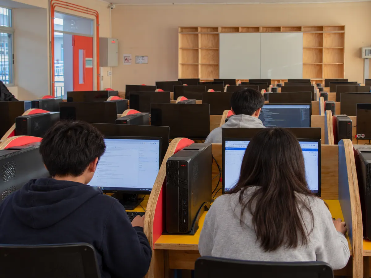 Estudiantes trabajando en sus puestos de computación